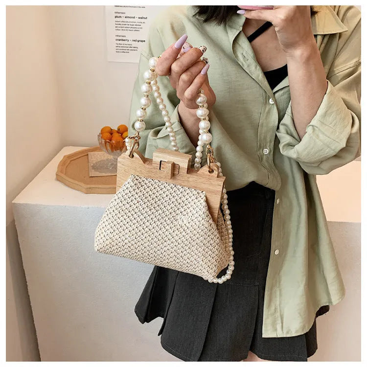 Women's woven straw shoulder bag with pearl chain details showing interior organisation compartments