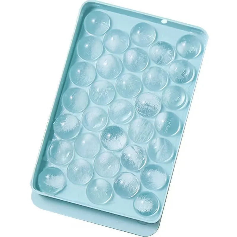 Blue silicone ice cube tray with lid showing round 33-grid design for homemade ice spheres