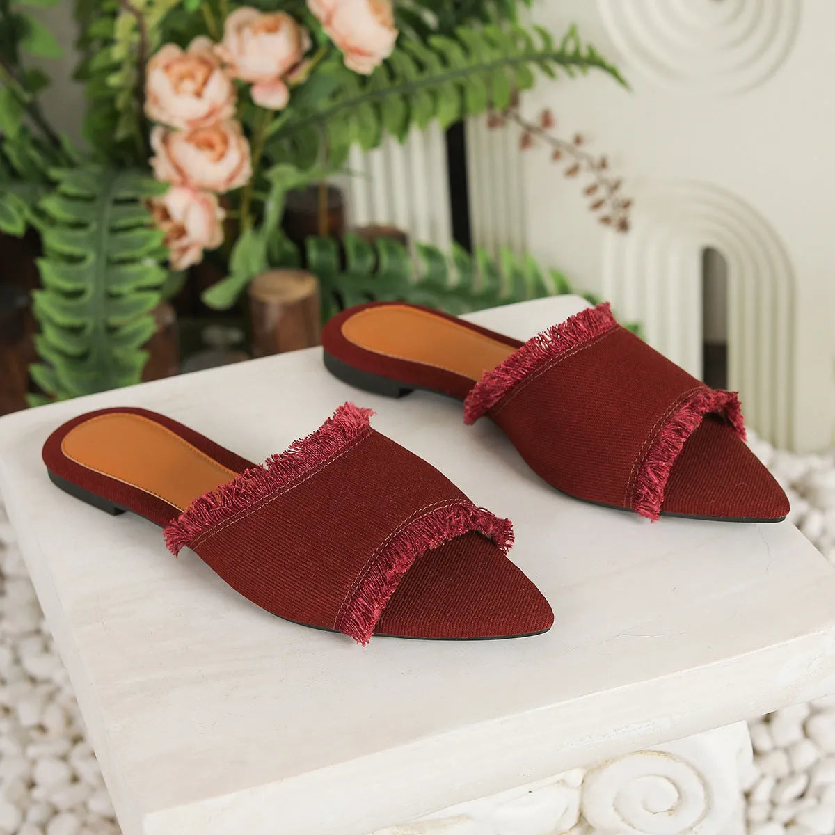 Women's denim flat slippers with tassel decoration and leather lining in apricot colour.