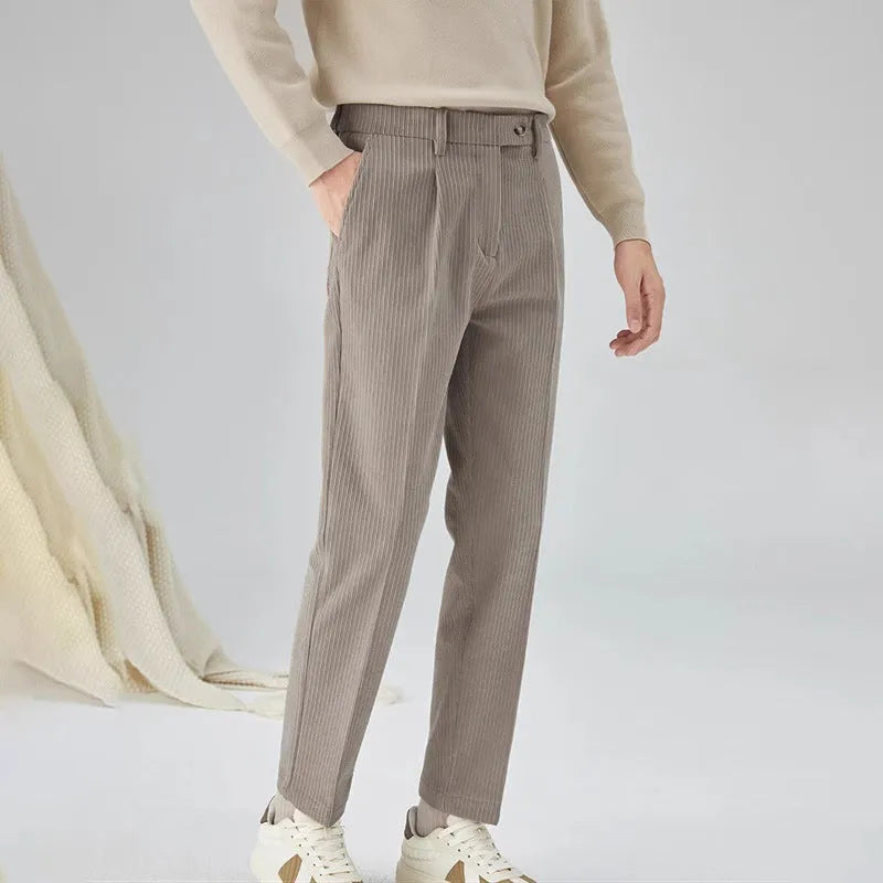 Men's straight-leg corduroy trousers in beige on a hanger, showing the textured fabric and mid-waist design.