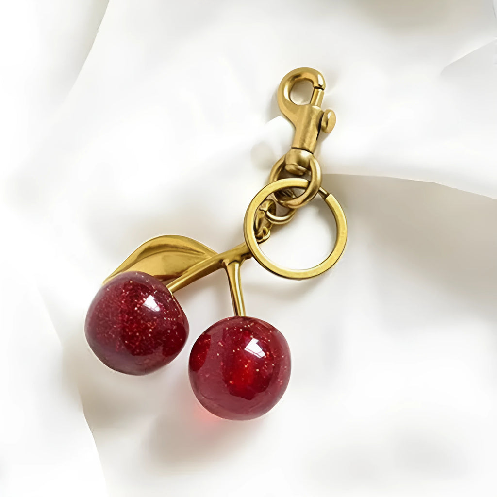 Three-dimensional cherry-shaped zinc alloy key ring pendant in pink or red colour.