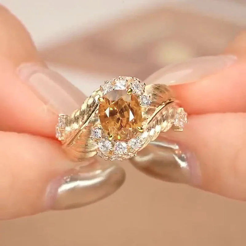 Gold-coloured copper women's ring with embossed feather design and inlaid yellow zircon stone.