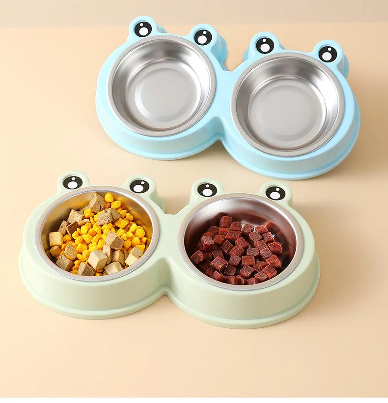 Blue stainless steel frog-shaped double pet bowl for food and water on a floor.