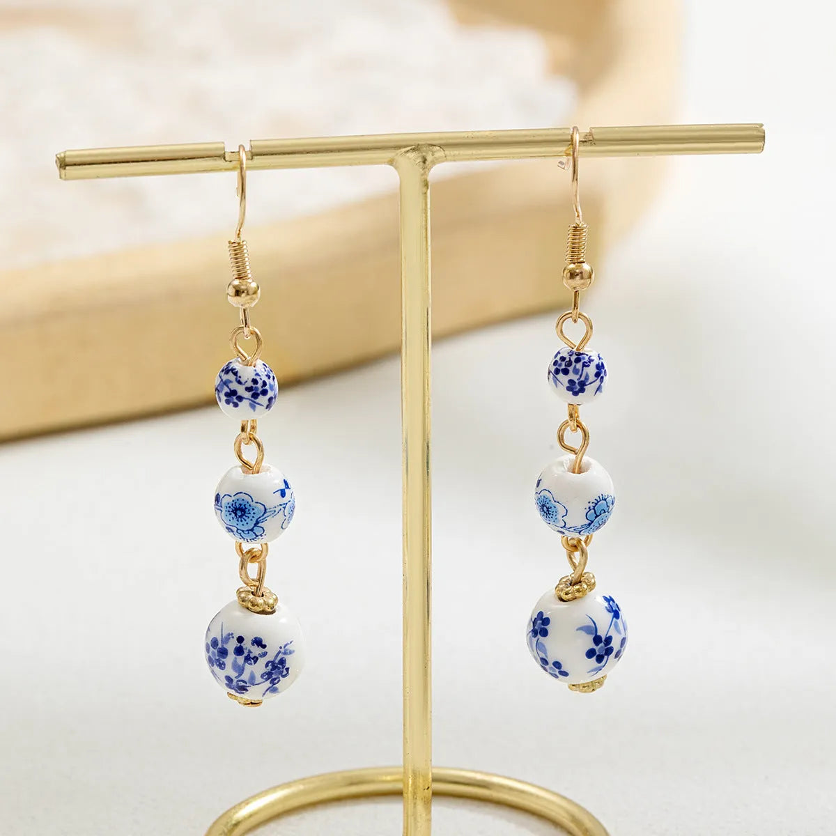 Long retro earrings with blue and white ceramic beads and geometric alloy parts.